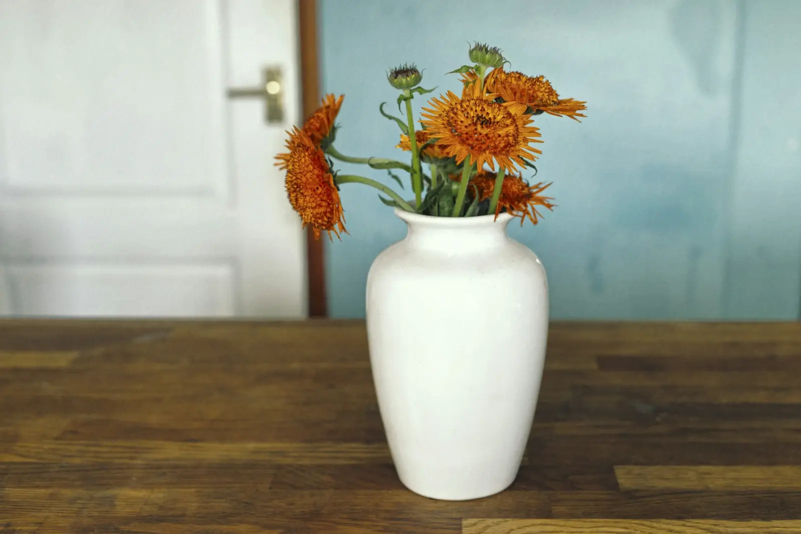 Orange und gelbe Blumen in einer weißen Vase